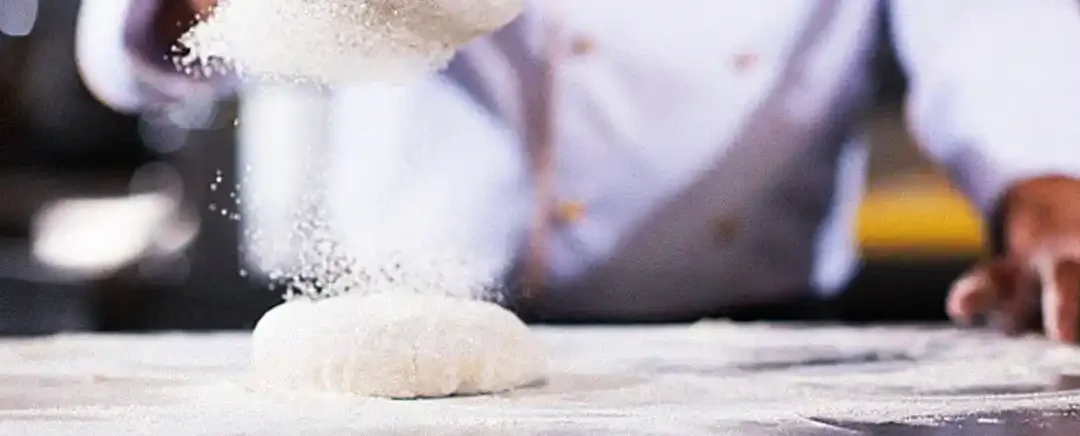 chef menabur tepung ke adonan